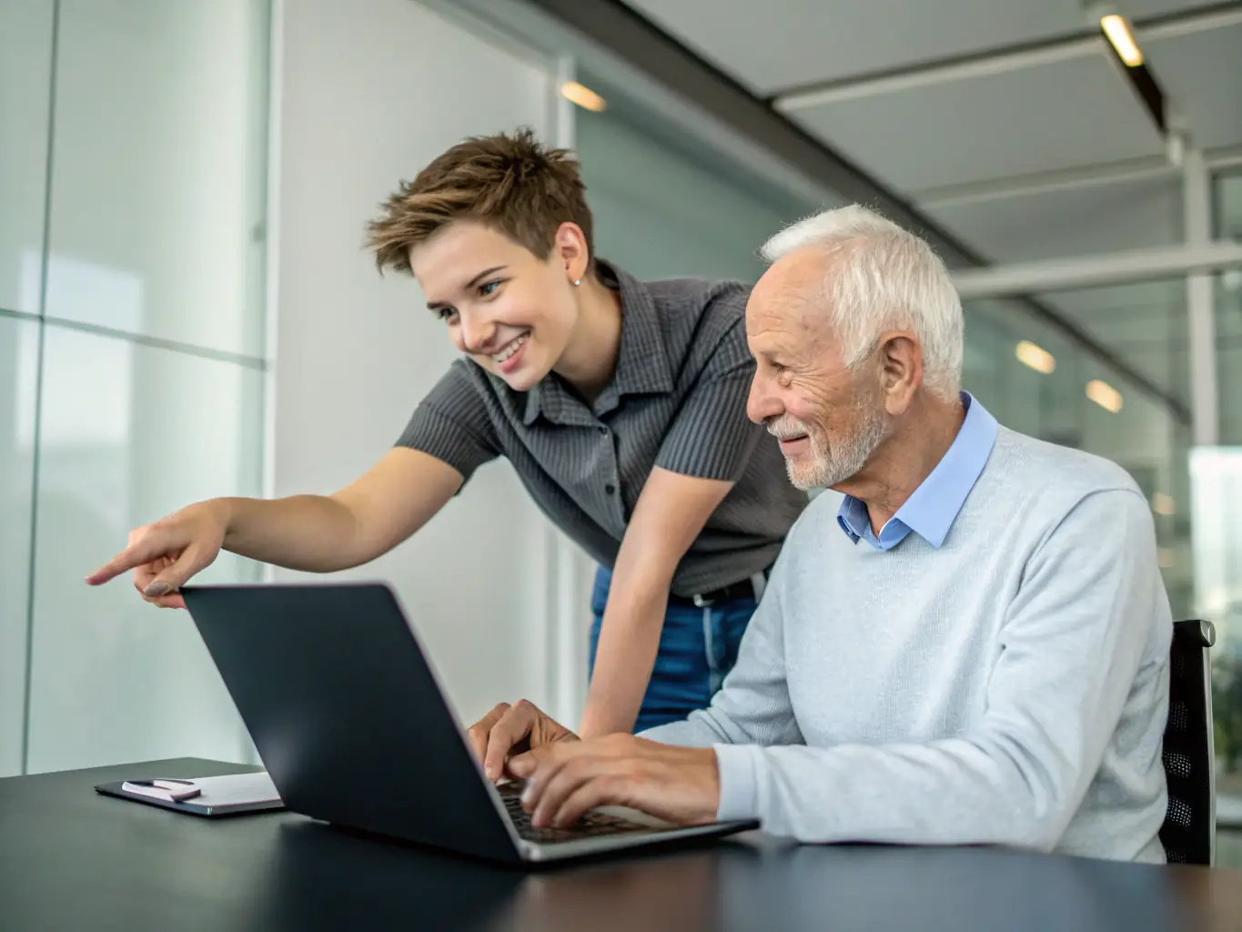 A friendly technician assisting a senior citizen with their laptop in a cozy living room setting, emphasizing ease of use and personalized support.